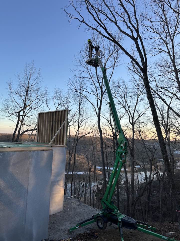 image of aerial bucket and man cutting down tree.